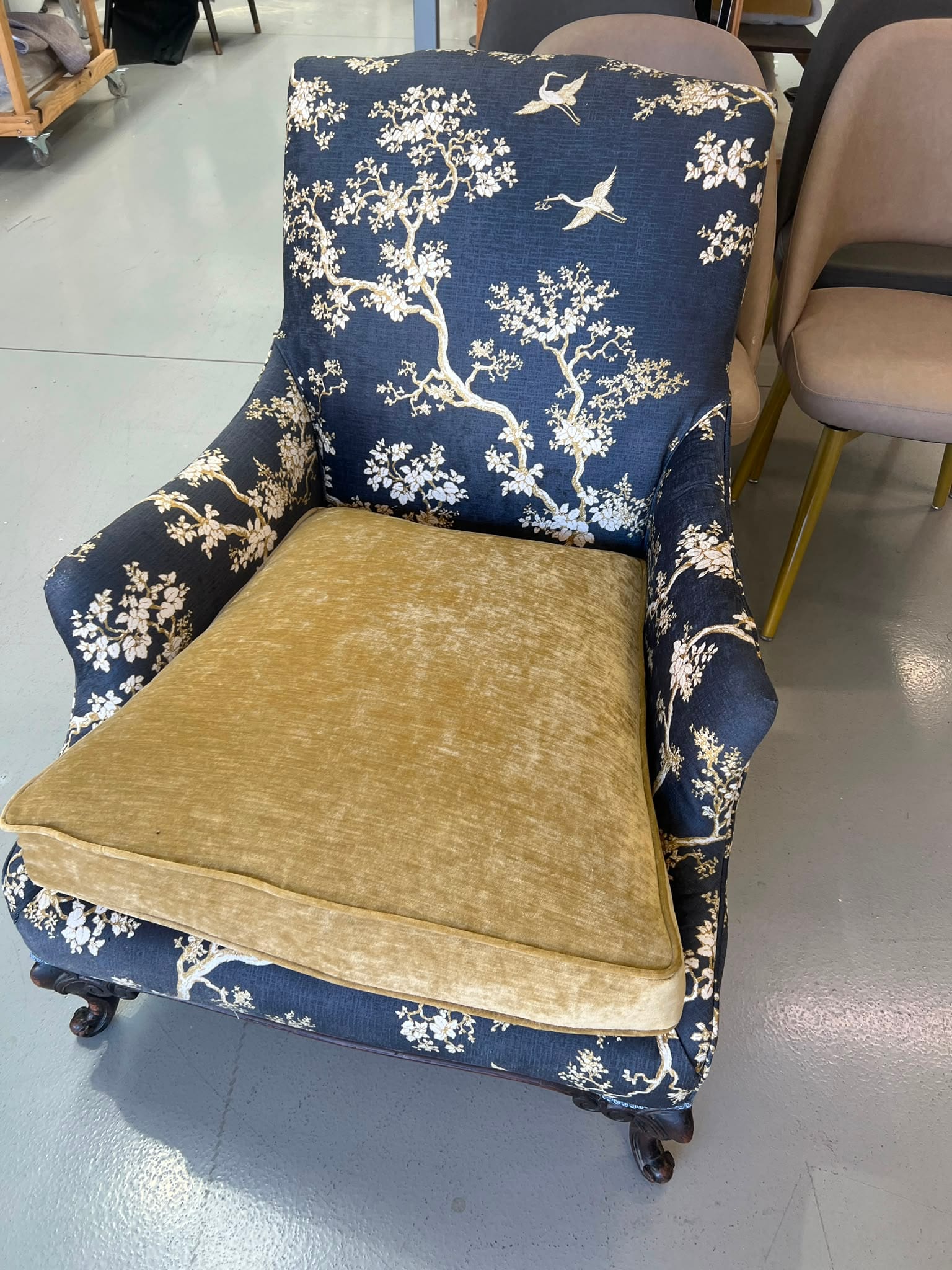 The piped velvet seat cushion and chinoiserie arms, close up