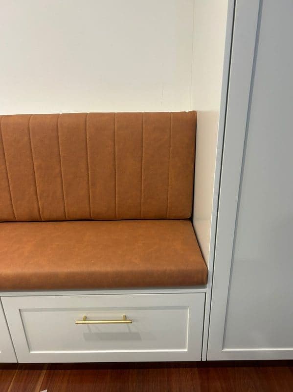 A channel-stitched banquette in tan leather