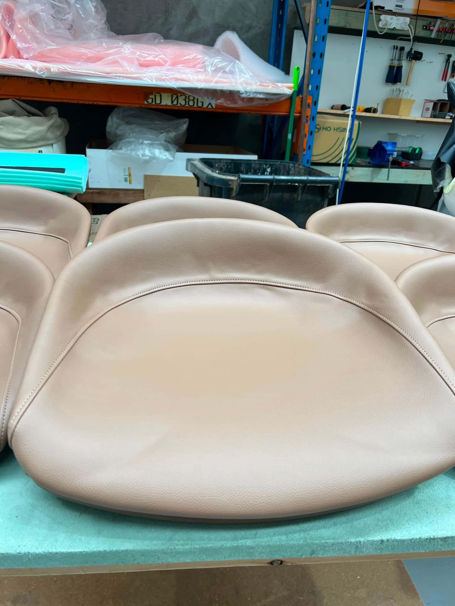 A run of moulded seat shells covered in blush leather