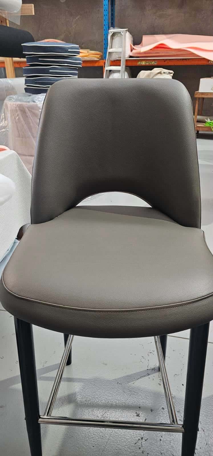 A counter stool upholstered in slate grey leather