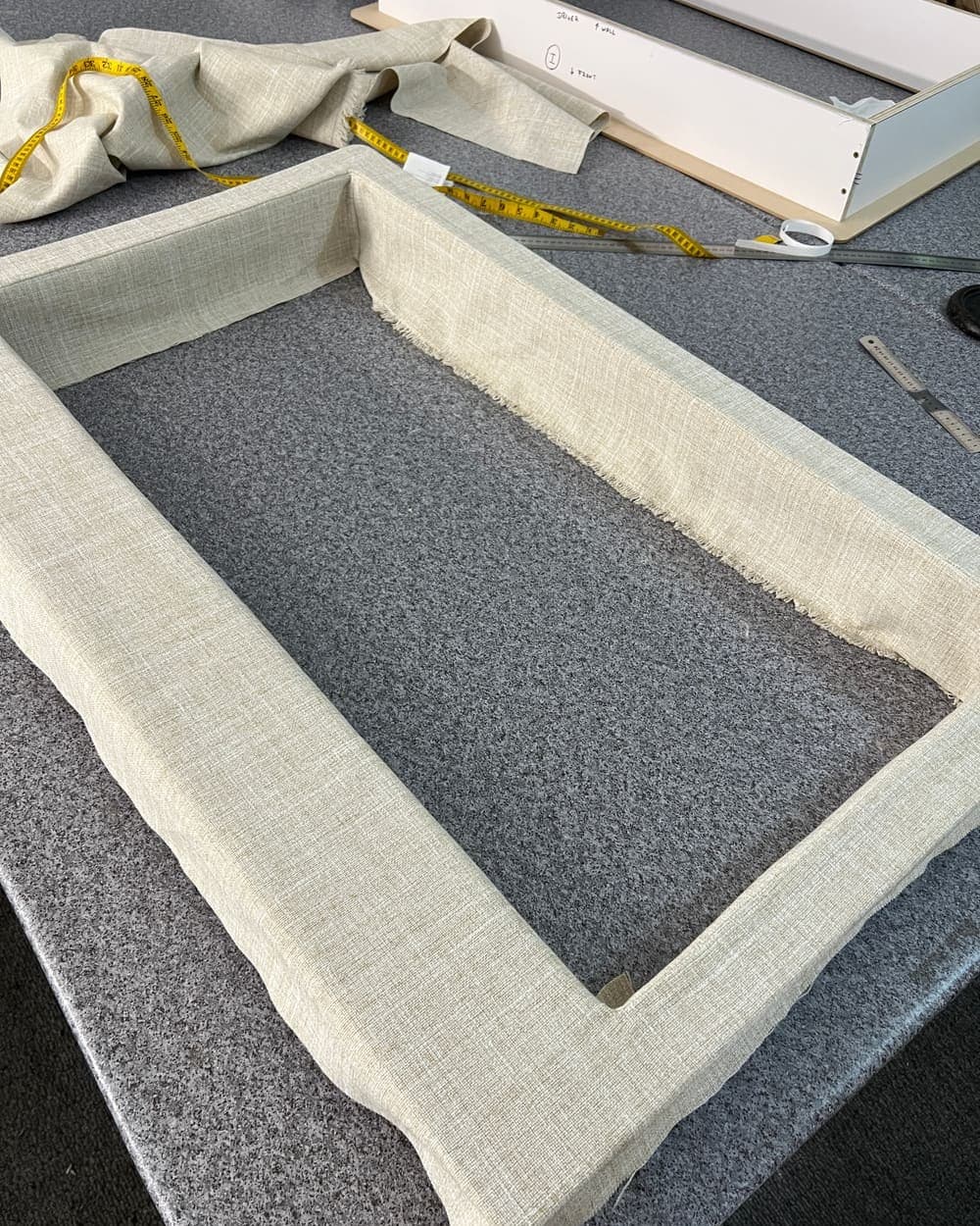 An insulated window cover upholstered to template